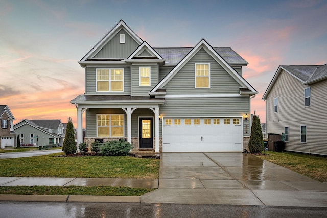 craftsman-style house featuring a yard and a garage