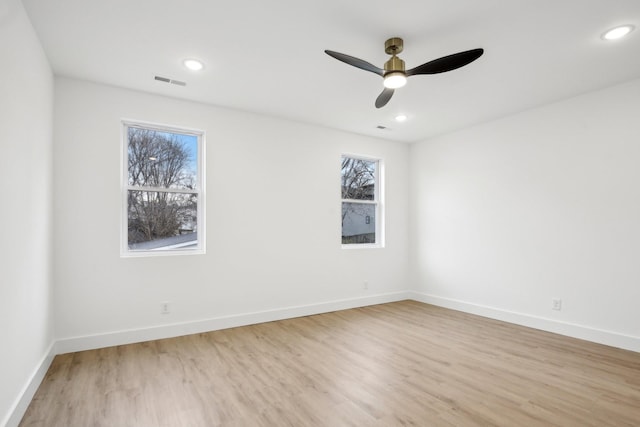 spare room featuring light hardwood / wood-style flooring, plenty of natural light, and ceiling fan