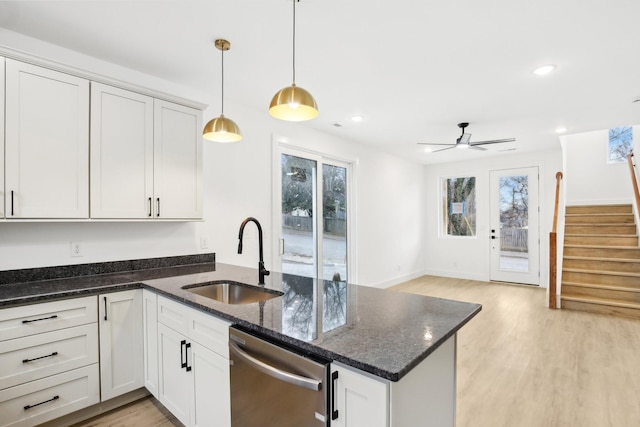 kitchen with stainless steel dishwasher, sink, and white cabinets