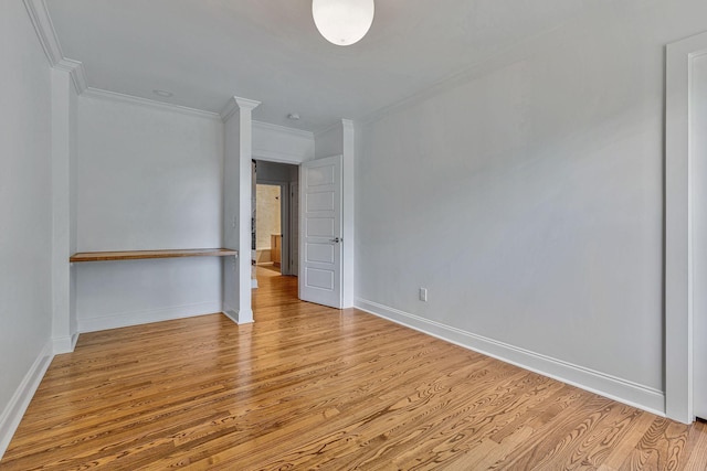 empty room featuring ornamental molding and light wood-type flooring