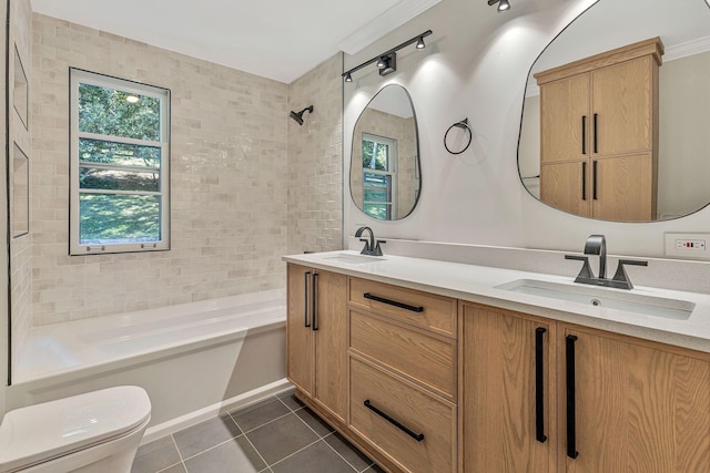 full bathroom with tile patterned flooring, vanity, tiled shower / bath, and toilet