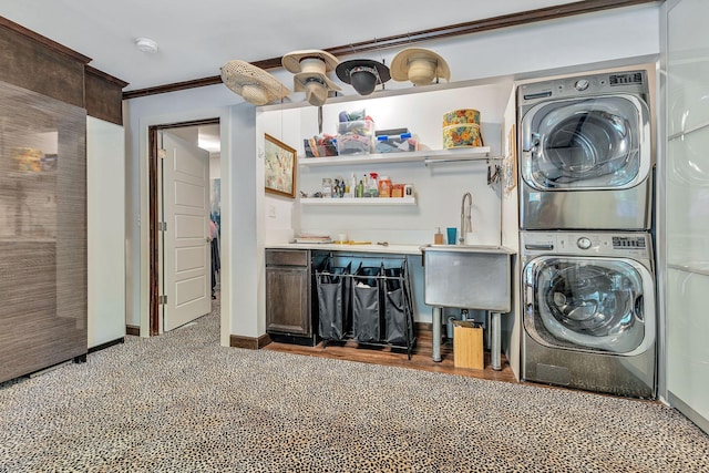 clothes washing area with ornamental molding, stacked washer and clothes dryer, and indoor wet bar