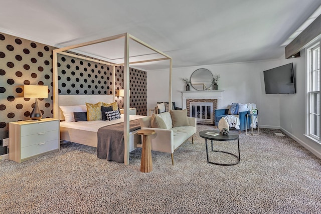 carpeted bedroom with ornamental molding and a fireplace