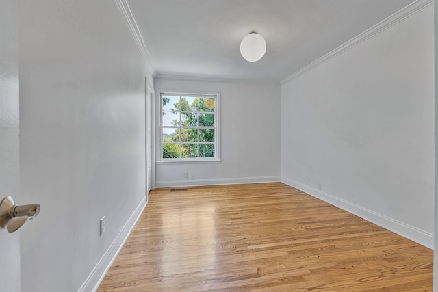 empty room featuring crown molding and light hardwood / wood-style floors