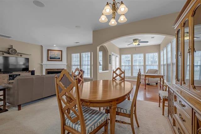 dining space featuring ceiling fan with notable chandelier