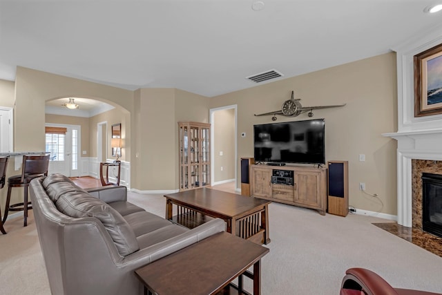 living room with a premium fireplace and light carpet