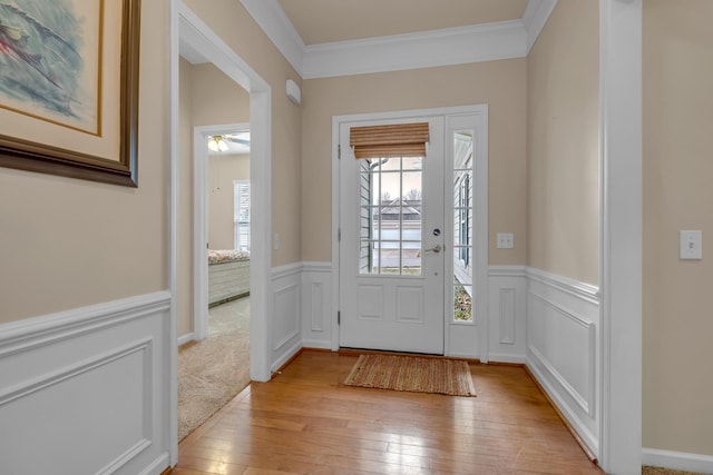 entrance foyer with crown molding and light hardwood / wood-style floors