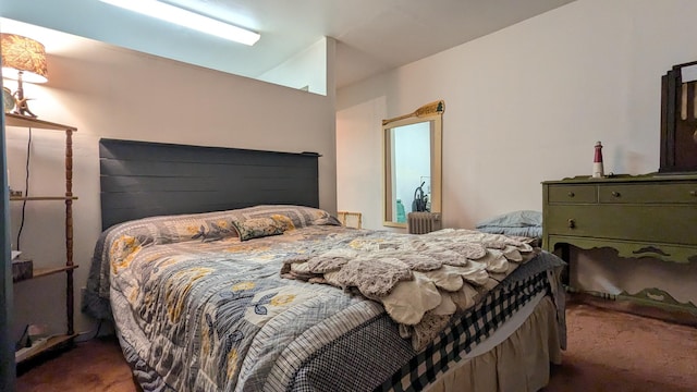 bedroom with vaulted ceiling and dark colored carpet