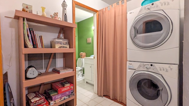 clothes washing area featuring stacked washer / dryer and light tile patterned floors