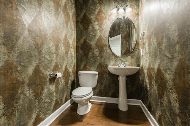 bathroom featuring hardwood / wood-style flooring and toilet