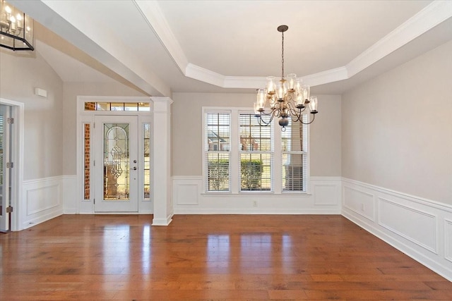 interior space with dark hardwood / wood-style floors, a raised ceiling, and a chandelier