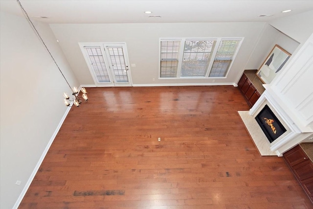 unfurnished living room featuring a healthy amount of sunlight and dark wood-type flooring