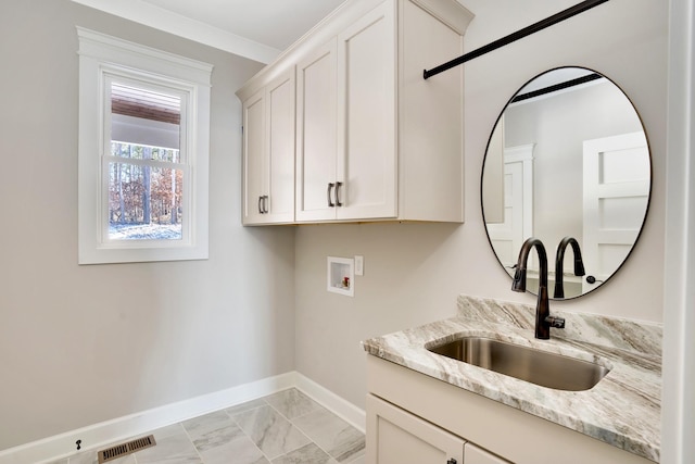 clothes washing area featuring cabinets, hookup for a washing machine, and sink