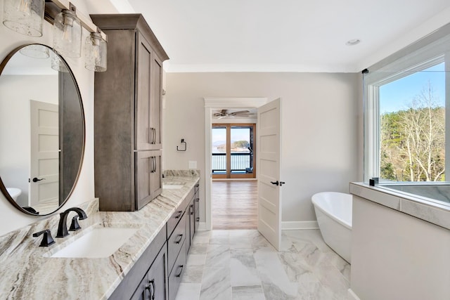 bathroom featuring vanity, a bath, and crown molding