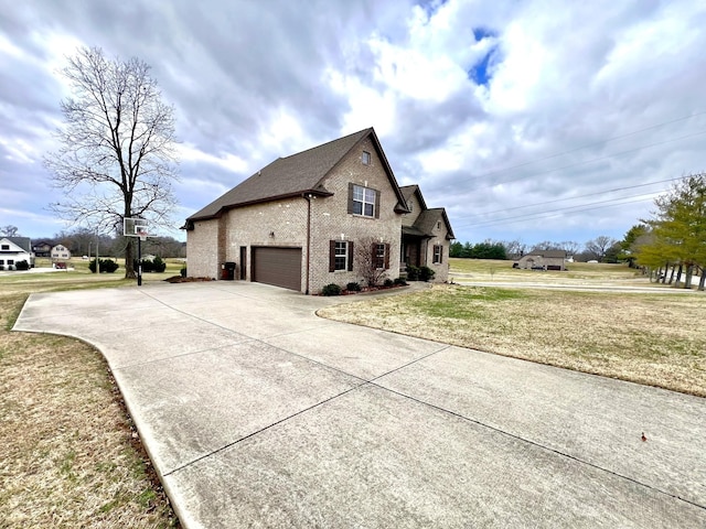 view of side of property featuring a garage and a yard