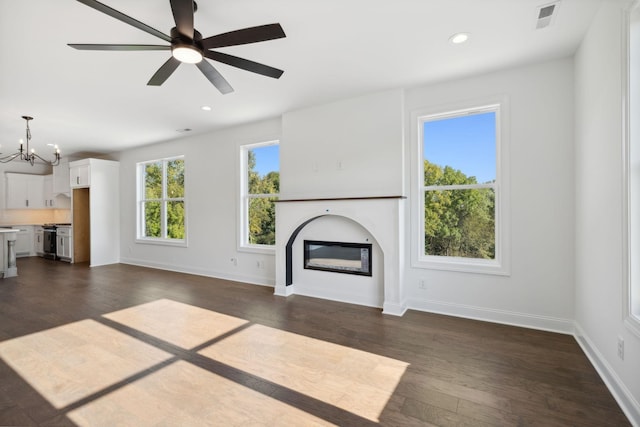 unfurnished living room featuring dark hardwood / wood-style floors and ceiling fan with notable chandelier