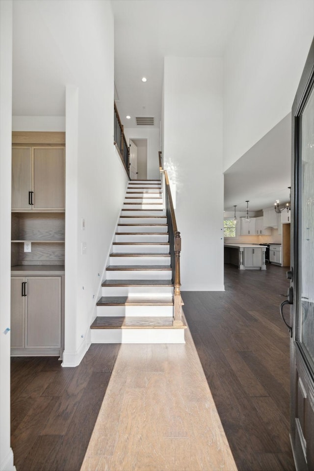 stairway featuring hardwood / wood-style flooring and a high ceiling