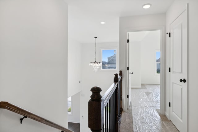 hallway featuring an inviting chandelier and a wealth of natural light