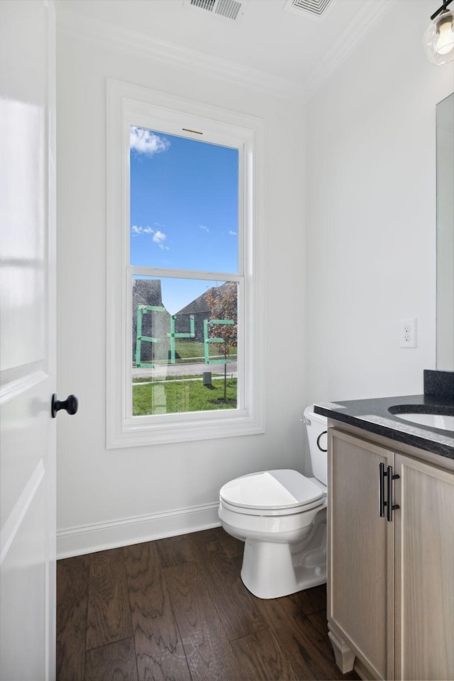 bathroom with hardwood / wood-style flooring, ornamental molding, toilet, and vanity