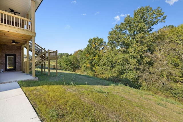 view of yard featuring a wooden deck, a patio area, and ceiling fan