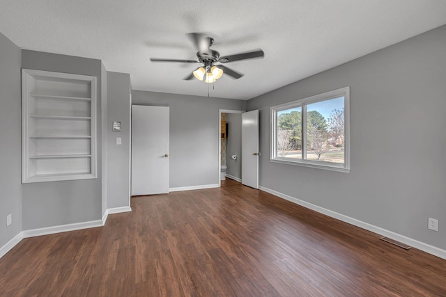 unfurnished bedroom featuring ceiling fan, dark hardwood / wood-style flooring, and a textured ceiling