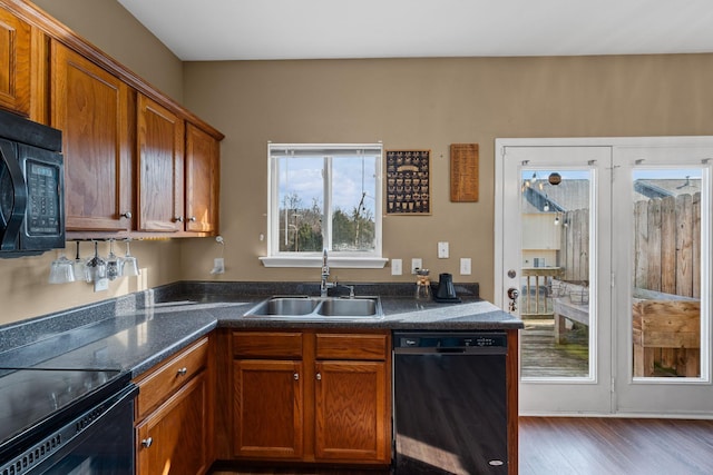 kitchen featuring dark hardwood / wood-style floors, sink, and black appliances