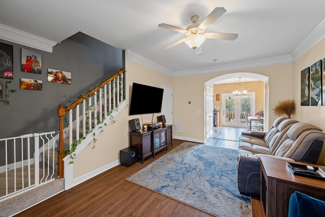 living room featuring hardwood / wood-style flooring, crown molding, and ceiling fan with notable chandelier