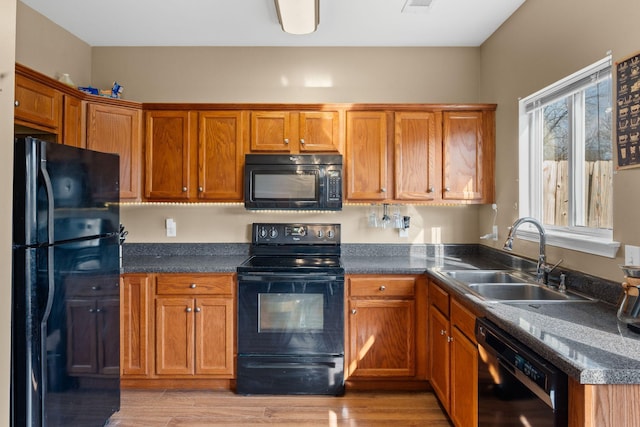 kitchen featuring sink, light hardwood / wood-style flooring, and black appliances