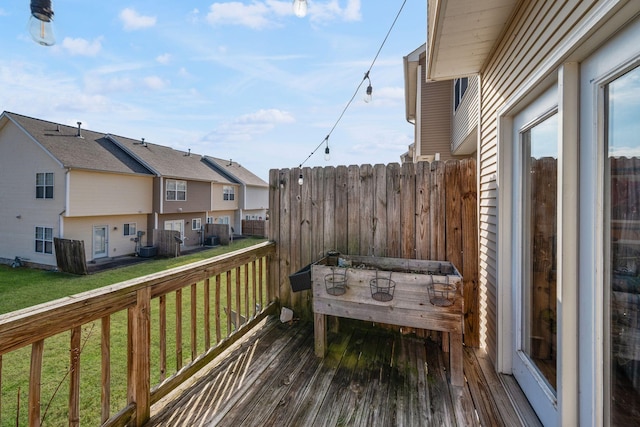 wooden deck featuring a lawn