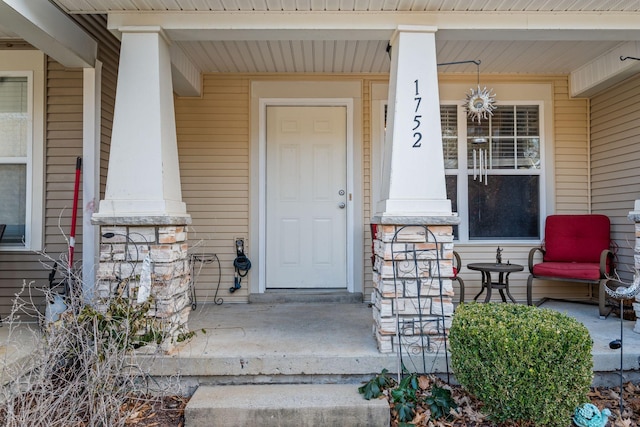 view of exterior entry featuring covered porch