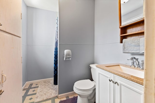 bathroom with toilet, vanity, baseboards, and tile patterned floors