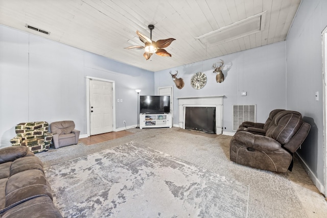 living area featuring wooden ceiling, visible vents, and ceiling fan