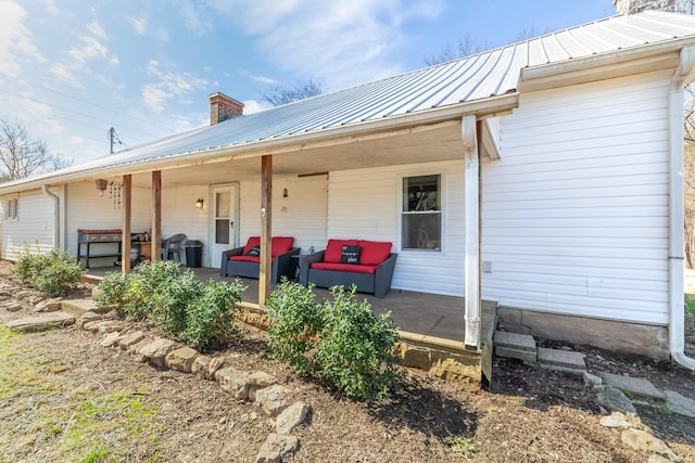 rear view of property featuring metal roof and a chimney