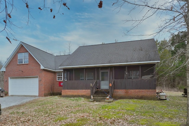 view of front of property with a front yard, a garage, and a sunroom