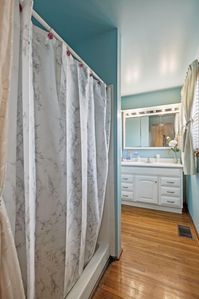 bathroom with shower / bath combination with curtain, vanity, and hardwood / wood-style floors