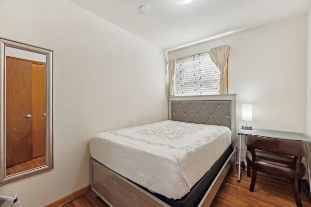 bedroom with dark hardwood / wood-style floors