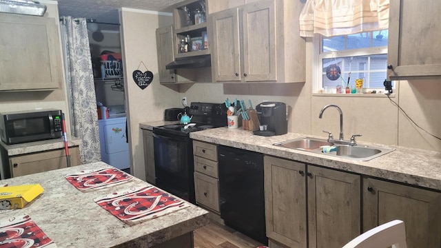 kitchen with wood-type flooring, washer / dryer, sink, black appliances, and a textured ceiling