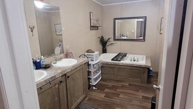 bathroom with a tub to relax in, vanity, hardwood / wood-style floors, and ornamental molding