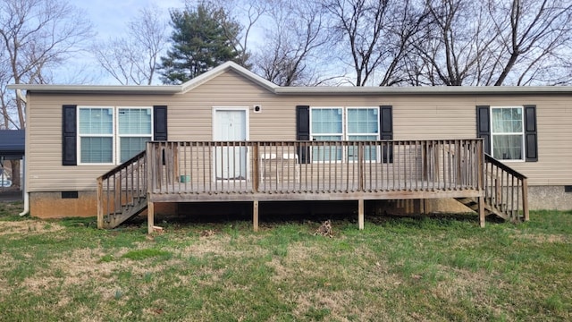 rear view of house featuring a deck and a lawn