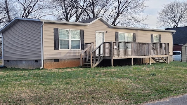 back of property featuring a deck and a lawn