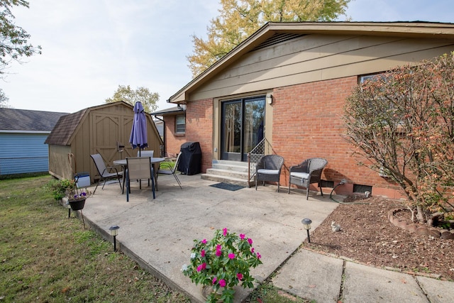 view of patio with a storage shed and a grill