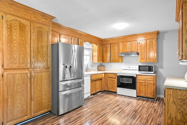 kitchen featuring stainless steel appliances, dark hardwood / wood-style floors, sink, and a textured ceiling