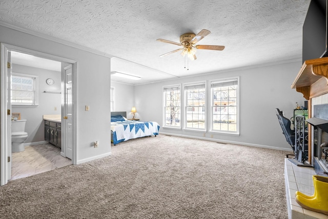 carpeted bedroom with ornamental molding, connected bathroom, a fireplace, and a textured ceiling