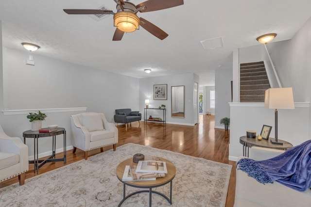 living room with ceiling fan, hardwood / wood-style flooring, and a textured ceiling