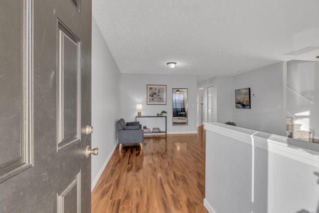 hallway featuring hardwood / wood-style flooring and a textured ceiling