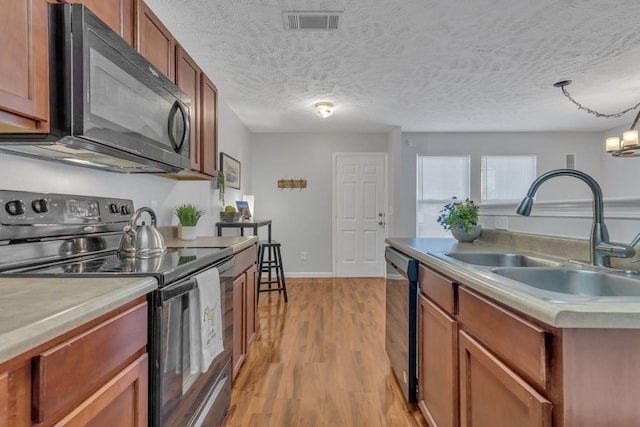 kitchen featuring range with electric cooktop, sink, stainless steel dishwasher, a textured ceiling, and light hardwood / wood-style flooring