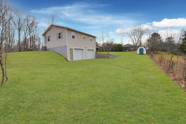 view of yard with a garage, a storage unit, and central air condition unit