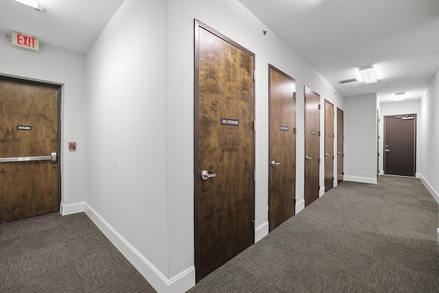 hall with dark colored carpet