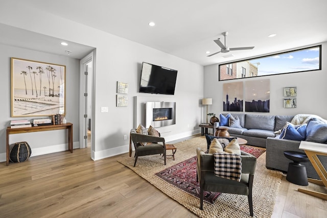 living room featuring light hardwood / wood-style flooring and ceiling fan