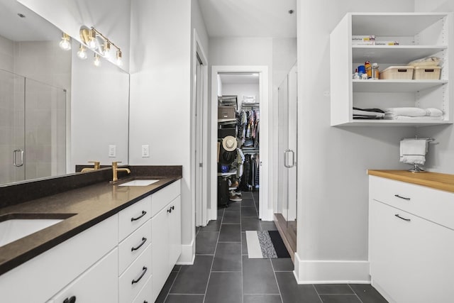 bathroom featuring tile patterned flooring, vanity, and a shower with shower door